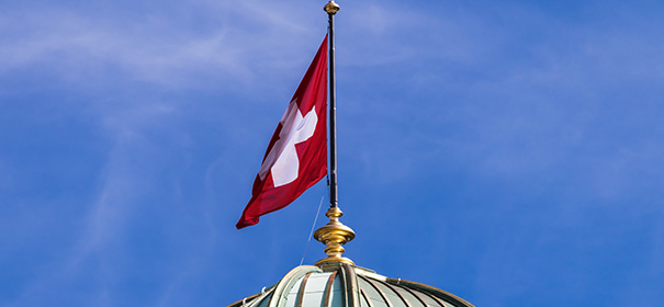 Schweizer Flagge über dem Bundeshaus © shutterstock, bearbeitet by islamiQ