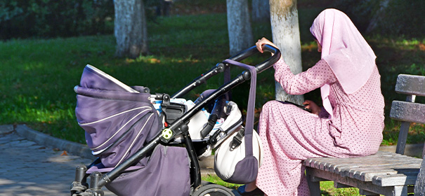 Symbolbild: Muslimin mit Kopftuch sitzt im Park © shutterstock, bearbeitet by iQ