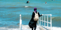 Symbolbild: Muslimin mit Burkini am Strand © shutterstock, bearbeitet by iQ