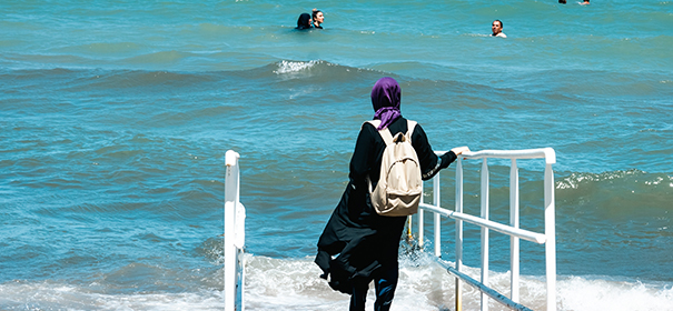Symbolbild: Muslimin mit Burkini am Strand © shutterstock, bearbeitet by iQ
